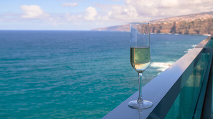 Champagne glass on hotel balcony with beautiful ocean view in  tropical country.