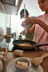 Girls cooking breakfast together at home kitchen