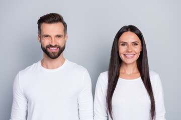 Portrait of attractive cheerful couple wearing white jumper isolated over grey pastel color background