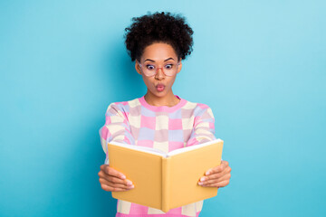 Portrait of attractive amazed funny wavy-haired girl reading book pout lips isolated over bright...