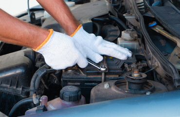 Replacing the battery before winter. Car maintenance before the cold season. Close up hand of Male mechanic changing car battery, engineer is replacing car battery