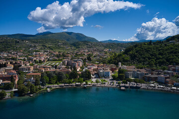 Fototapeta na wymiar Aerial view of the city of Garda, Lake Garda, Italy. Vista lago on the coastline. Panorama on corno. Top view of the Museum of Lake Garda on the coastline.