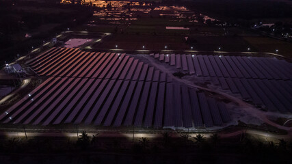 Aerial view of a solar farm producing clean energy during the evening with twilight and visible all around area