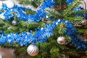 Silvery Christmas balls, blue tinsel on a Christmas tree