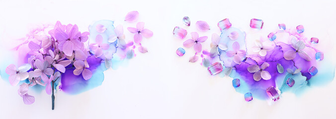 Naklejka na ściany i meble Creative image of pink and purple Hydrangea flowers on artistic ink background. Top view with copy space