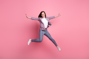 Full body photo of young cheerful girl have fun jump up active hands isolated over pink color background