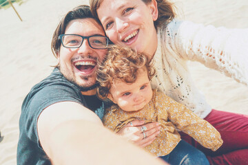 Young family posing together for a selfie in their holidays