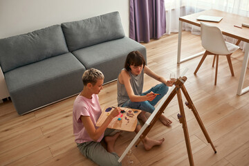 Top view of young lesbian girls painting picture