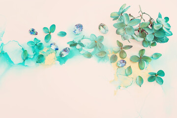 Obraz premium Creative image of emerald and green Hydrangea flowers on artistic ink background. Top view with copy space