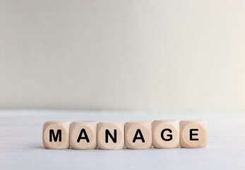 Wooden cube with the wordMANAGE text. Business concept.