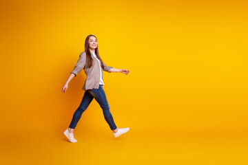 Fototapeta na wymiar Full body profile side photo of young attractive woman walk meeting wear casual clothes isolated over yellow color background