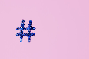 blue shiny hashtag on a light pink background. Online technology concept and social media...