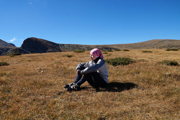 Naklejka na ściany i meble teen girl resting in nature sitting on the ground