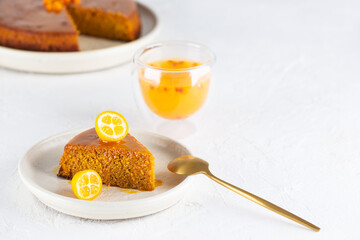 Homemade sea buckthorn cake with orange on a plate with a glass of tea. Sugar, gluten and lactose free and vegan.