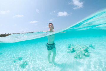Man walking on sand seabed of beautiful turquoise sea. Tourist enjoying beach holiday. .