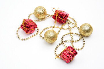Christmas golden balls and gifts in red packaging tied by a chain on a white background