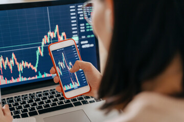 Close up of woman stock market investor analyst holding a smartphone investment app index growth...