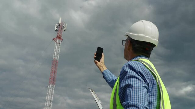 Telecommunications engineer checking the signal from a telecommunications tower