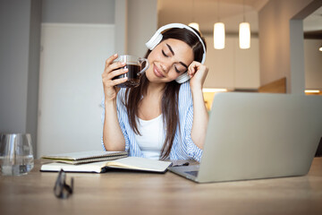 Young woman talk on video call at the table using headphones Remote work