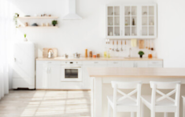 Blurred background with family dining room and minimalist kitchen interior, kitchenware and utensils on furniture