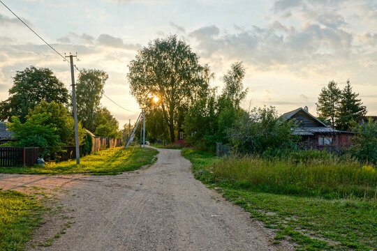 Russian village in Novgorod Oblast. Wooden house and gravel road. Summer Sunset. High quality photo