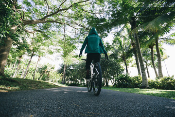 Woman riding bike at park without holding the handlebar on sunny day