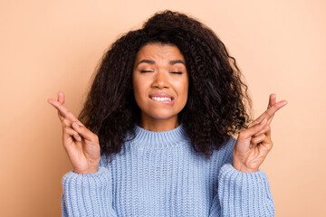 Photo of young woman anxious worried wish success pleading expect isolated over beige color...