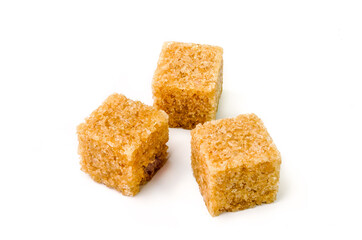 Three cubes of brown sugar with shadow on white background
