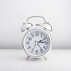 Gray glossy metal alarm clock isolated on white background. Isolate