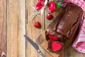 St. Valentine's Day, Birthday or Mother's Day dessert, homemade festive food. Homemade sweet chocolate brownie cake with red heart on a wooden rustic tabletop. Top view flat lay. Copy space.