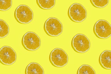 Lemon slices pattern, top view of lemon slices isolated on a yellow background.
