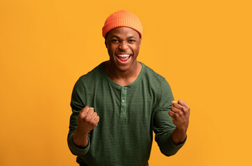 Hooray. Euphoric Excited Black Hipster Guy Celebrating Success With Raised Fists