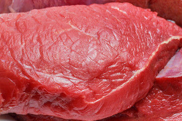 A piece of raw red meat beef fillet close-up. Food background. Source of vitamins B, A, amino...