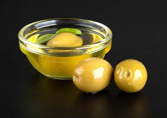 Olives and olive oil isolated on a black background with reflection