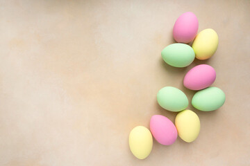 Easter flat lay. Eggs painted in pastel colors on beige background, space for text