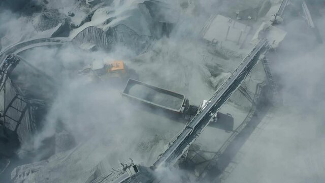 Granite mining by open-pit method. The video shows loading. The loader loads the mass into a dump truck.