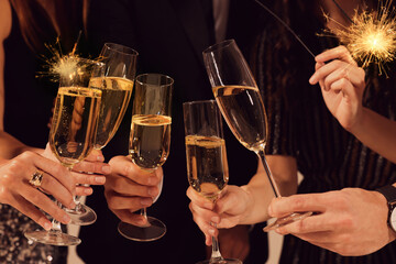 Friends clinking glasses of sparkling wine, closeup. New Year celebration