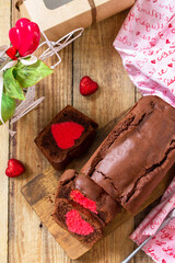 St. Valentine's Day, Birthday or Mother's Day dessert, homemade festive food. Homemade sweet chocolate brownie cake with red heart on a wooden rustic tabletop. Top view flat lay.