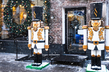 Street cafe in winter. Wooden figures of soldiers at the entrance to the cafe. Christmas decor on the windows.Festive mood. Christmas Holidays and New Year Holidays. Europe. Minsk