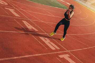 Fit young woman running sprinting at the racetrack. Fit runner fitness runner during outdoor...