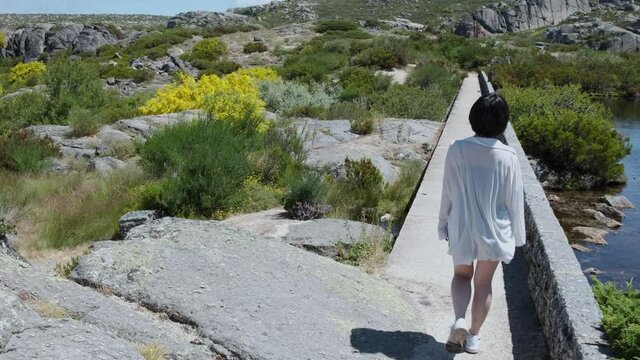 A woman turns down a walkway next to Cov&atilde;o dos Conchos.