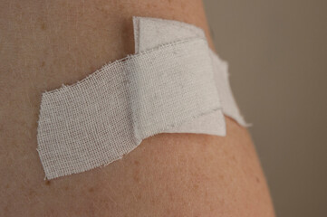 Woman using adhesive bandage plaster on her arm after injection vaccine.