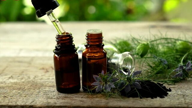 Black cumin oil in a bottle. Selective focus.