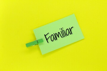 green paper clamped with the word Familiar