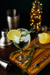 Fresh Mojito cocktail with lemon, rosemary and ice in jar glass on dark blue background. Summer cocktail