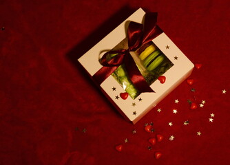 White box with macaroons. A romantic gift. Red velvet background. Space for text.