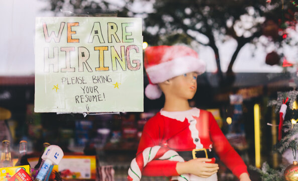 hand made we are hiring sign in a storefront window help wanted 