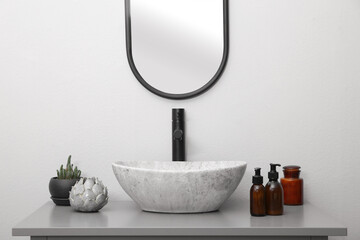 Dispensers of liquid soap and decor near sink in bathroom