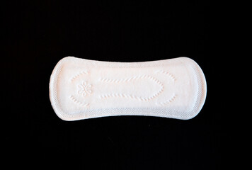 One Discrete Panty Liner or Pad for Woman on Black background. Daily Hygiene Products, Women's Pads for Every Day Hygiene Care. Copy space