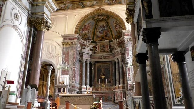 Tilt up shot showing interior of famous Amalfi Cathedral, altar at the front and beautiful religious artwork above and ceiling of the church.